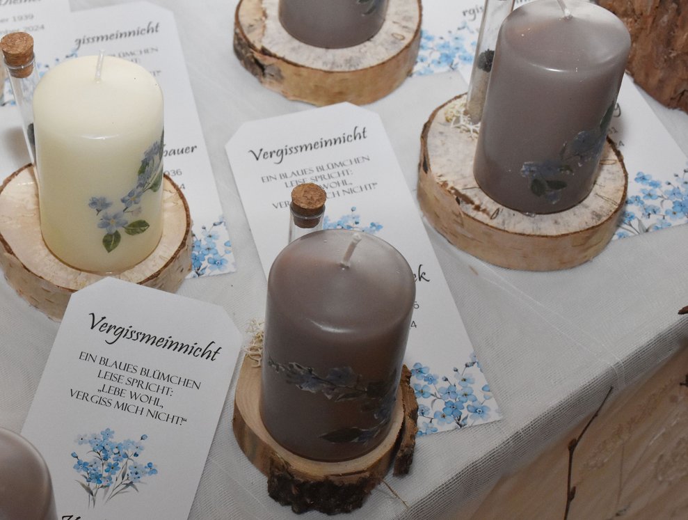 Dekoration mit Kerzen und Samen der Vergissmeinnicht-Blume.