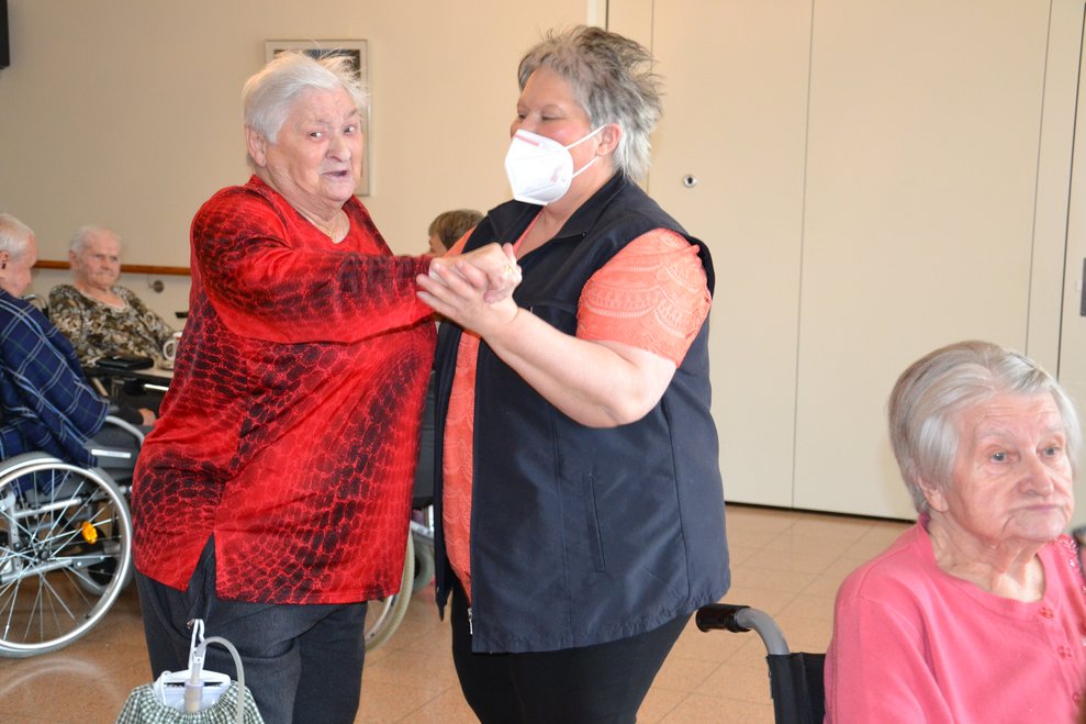Bewohnerin und Betreuerin tanzen