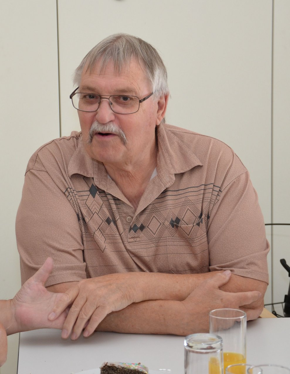 Herr Schreier sitzt an einem Tisch