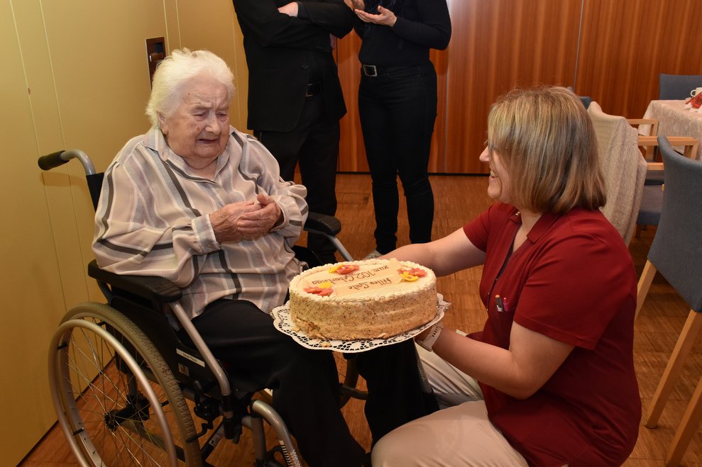 Fr. Fröhlich bekommt eine Torte überreicht.