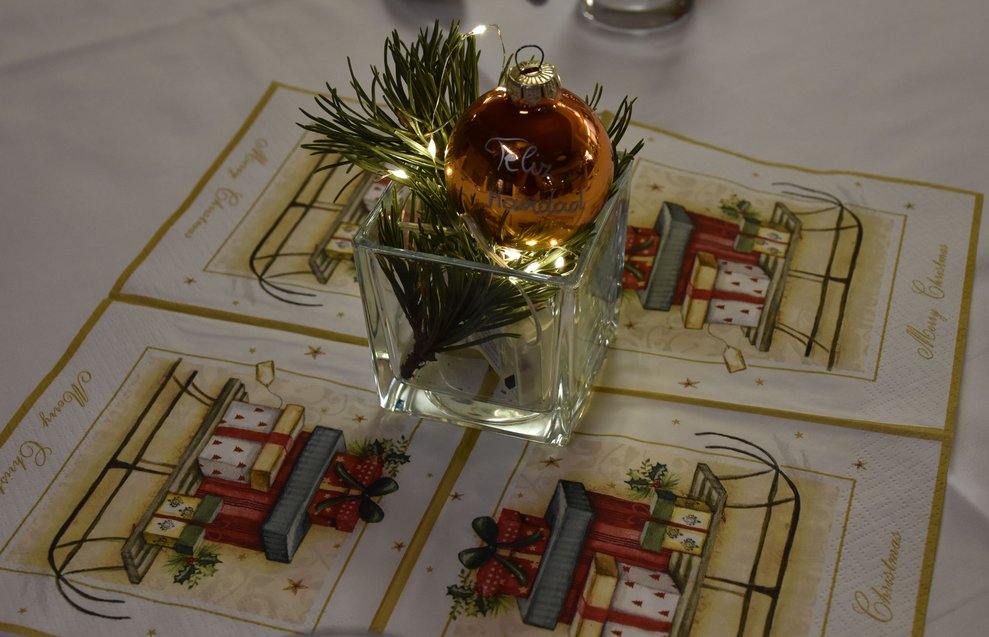 Tischdekoration mit Weihnachtskugel und Beleuchtung. 