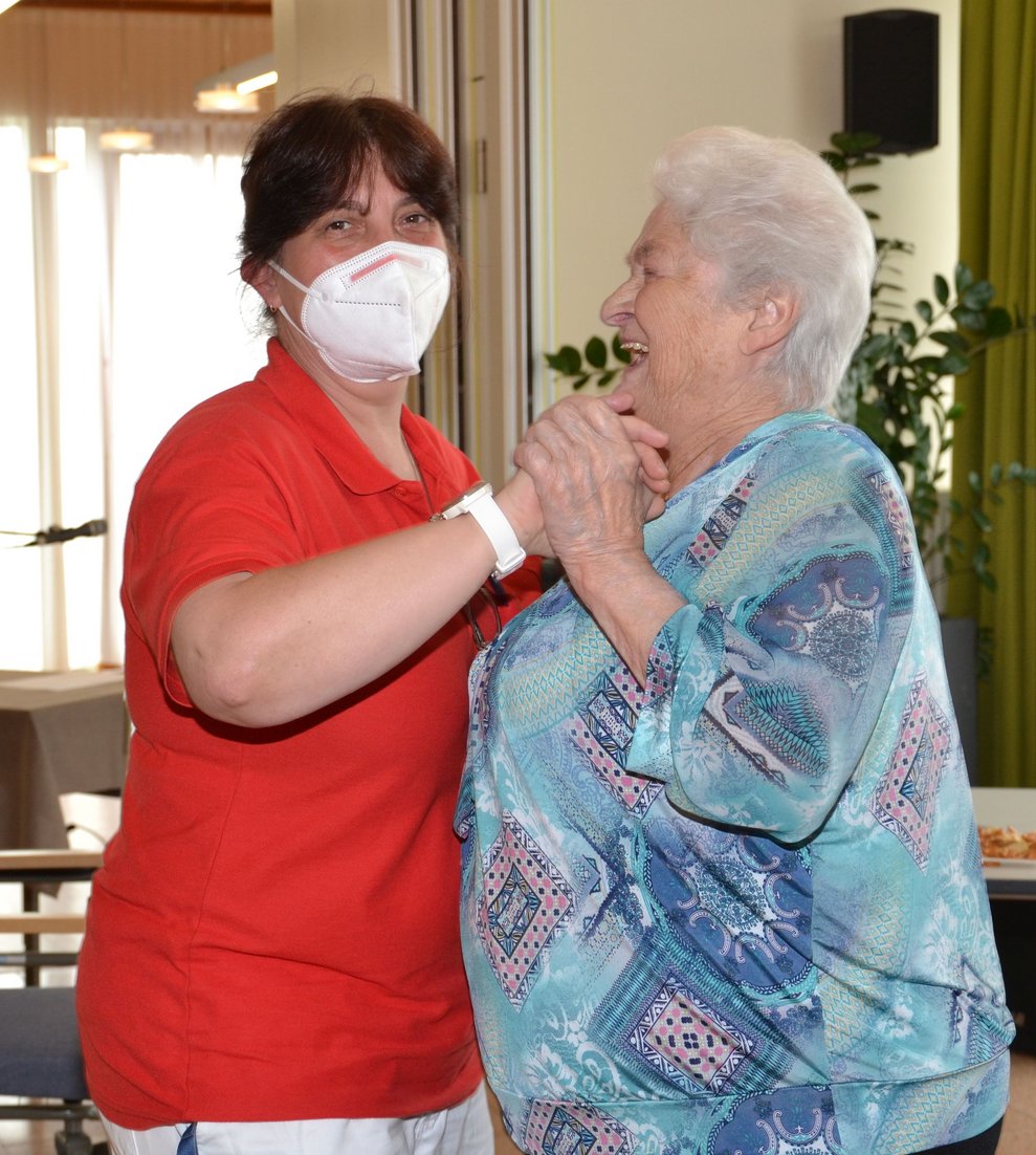 Betreuerin tanzt mit Bewohnerin