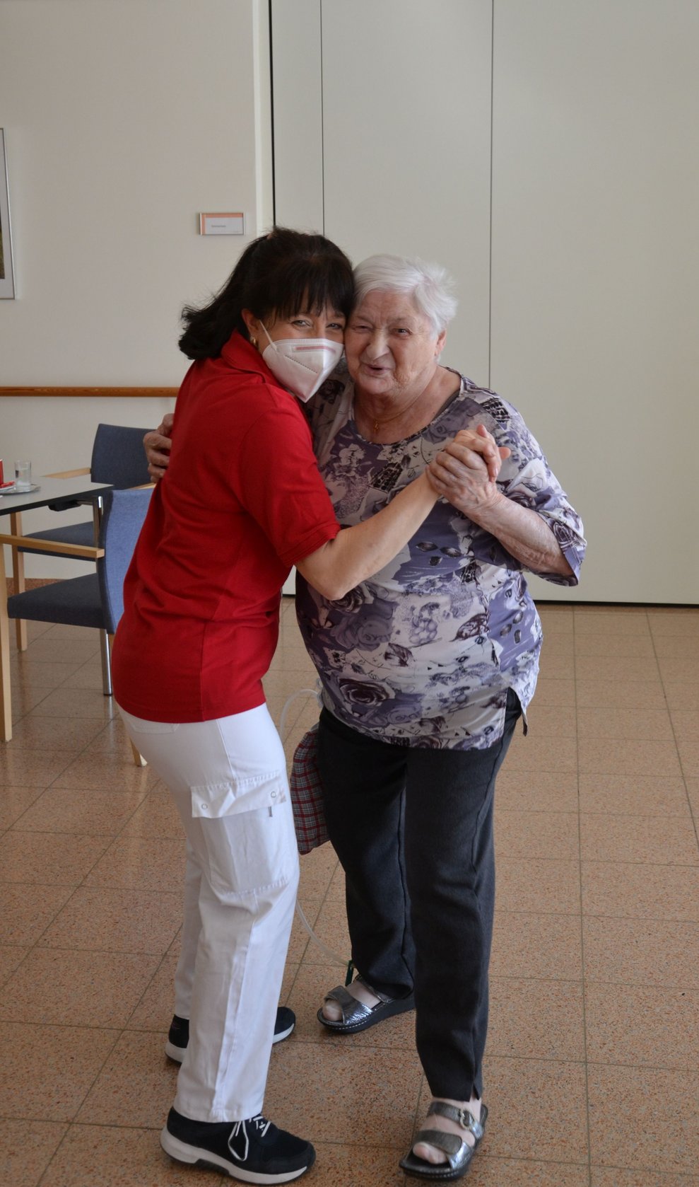 Bewohnerin und Betreuerin tanzen