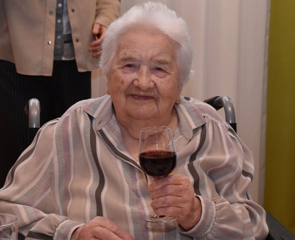 Fr. Fröhlich erhebt ihr Glas Wein.