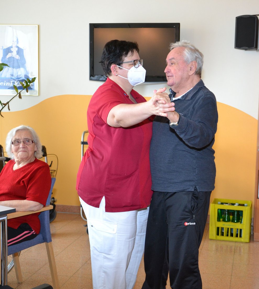 Zwei Kolleg: innen tanzen.