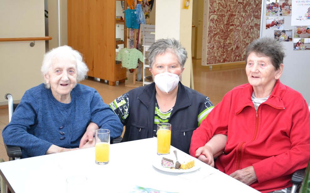 Michaela sitzt zwischen zwei Bewohnerinnen